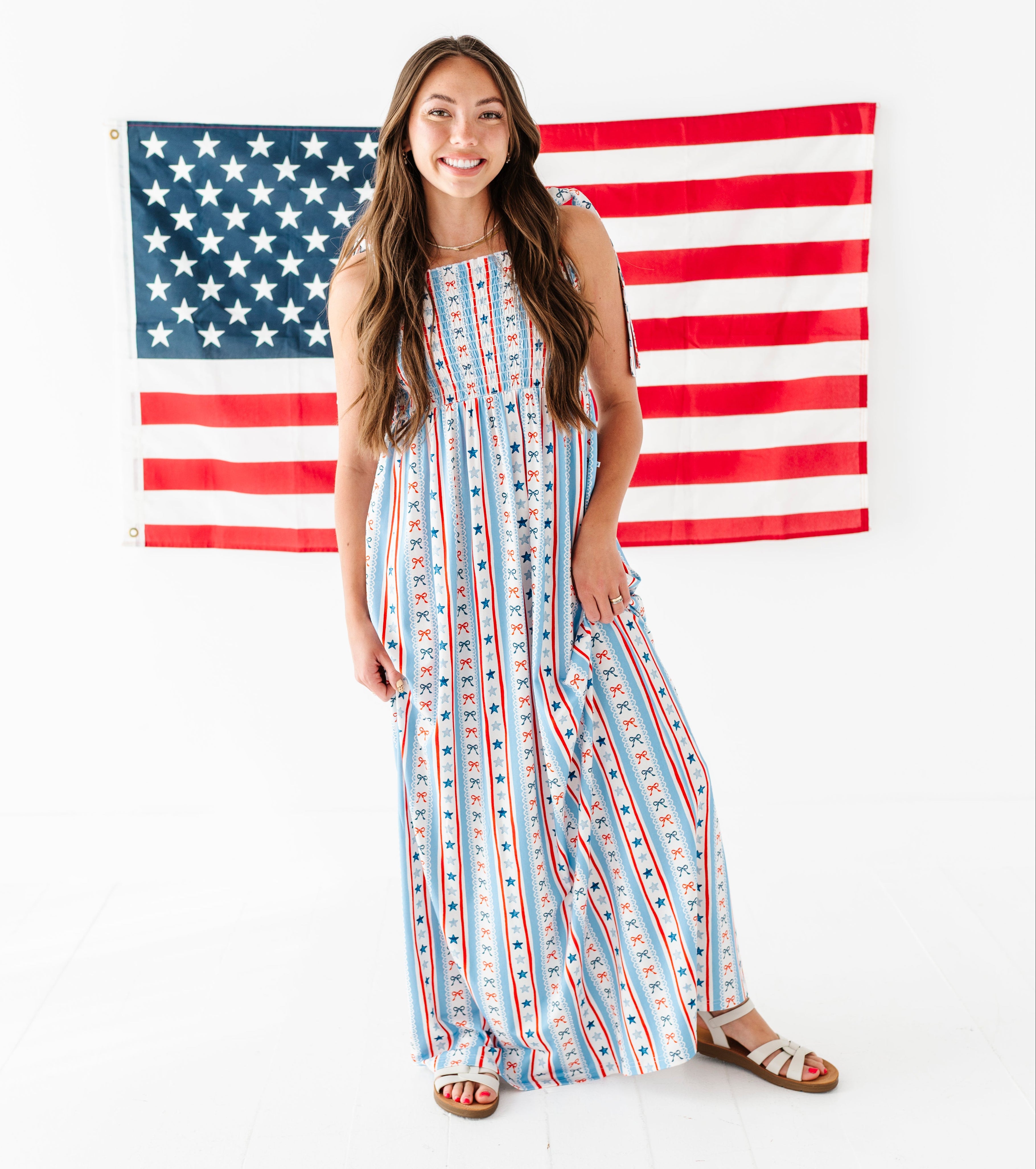 Woman in a striped bamboo-cotton maxi dress standing in front of an American flag